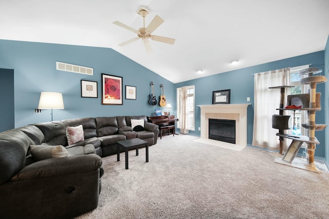 carpeted living area with lofted ceiling, a fireplace with flush hearth, visible vents, and ceiling fan