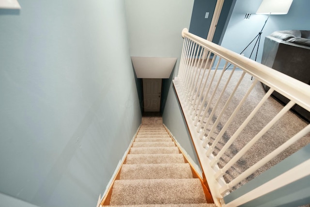 stairs featuring carpet flooring and baseboards