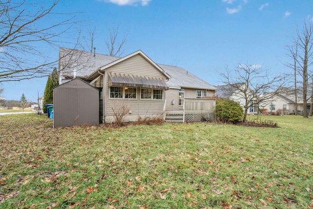 exterior space featuring a shingled roof, a deck, a yard, an outbuilding, and a storage unit