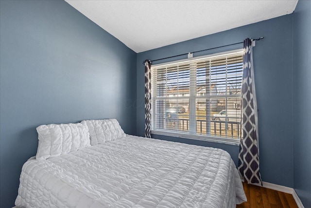 bedroom with baseboards and wood finished floors