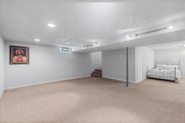 basement featuring stairway, carpet flooring, and a textured ceiling