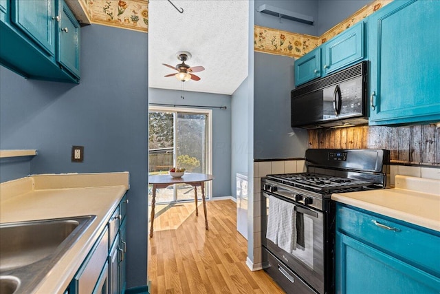 kitchen featuring black appliances, blue cabinetry, light wood-style flooring, and light countertops