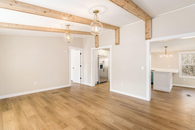 unfurnished living room with beamed ceiling, baseboards, light wood-style floors, and visible vents