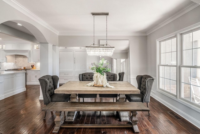 dining space with crown molding, dark wood-style floors, visible vents, and baseboards