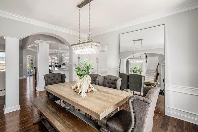 dining space with crown molding, baseboards, dark wood-type flooring, and ornate columns