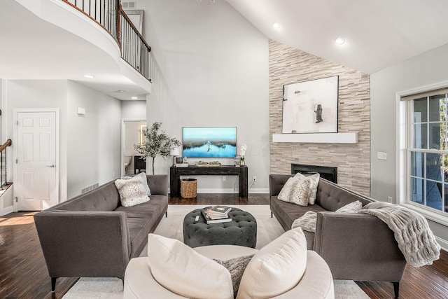 living room with wood finished floors, baseboards, high vaulted ceiling, recessed lighting, and a tile fireplace