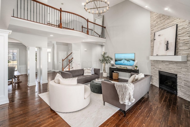 living area with decorative columns, hardwood / wood-style floors, and a fireplace