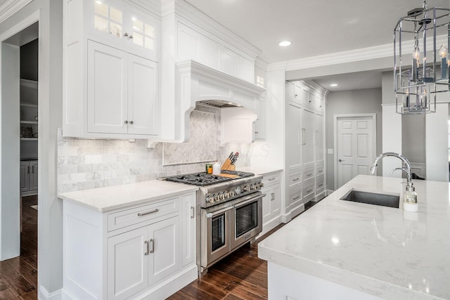 kitchen with range with two ovens, light stone countertops, dark wood-type flooring, and a sink