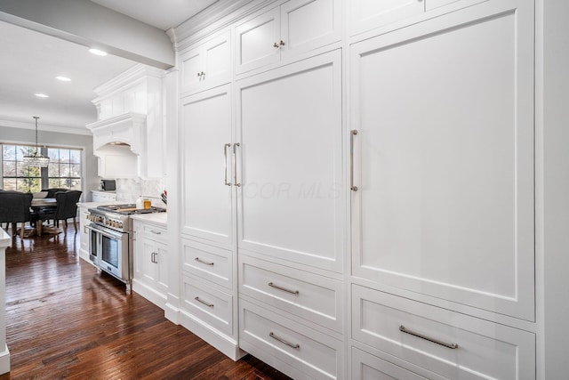 kitchen with double oven range, tasteful backsplash, dark wood-style floors, white cabinetry, and crown molding