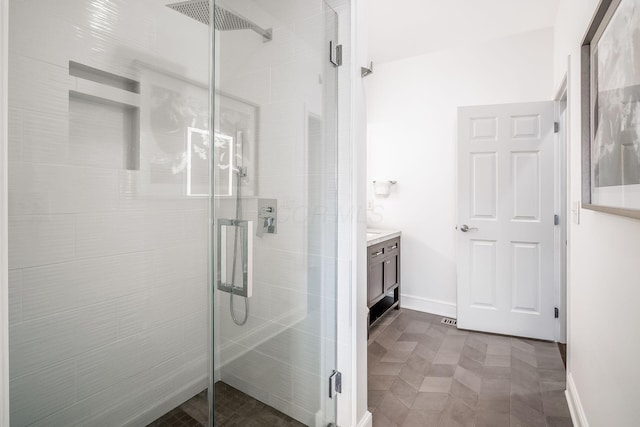 bathroom featuring vanity, a shower stall, and baseboards