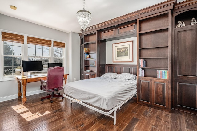 bedroom with dark wood finished floors, a notable chandelier, and baseboards