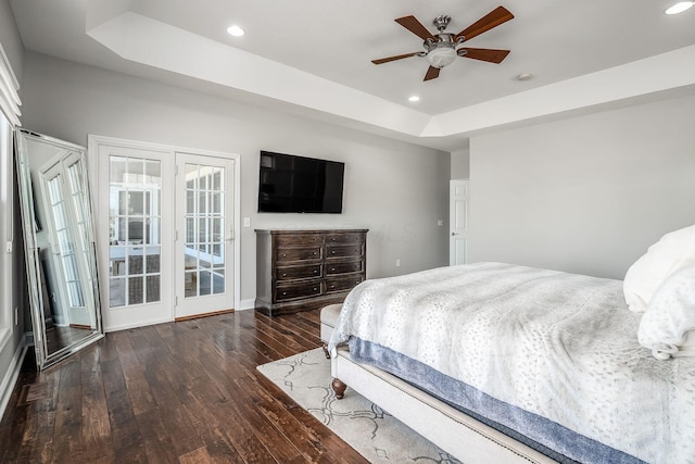 bedroom with a ceiling fan, a tray ceiling, hardwood / wood-style flooring, and recessed lighting