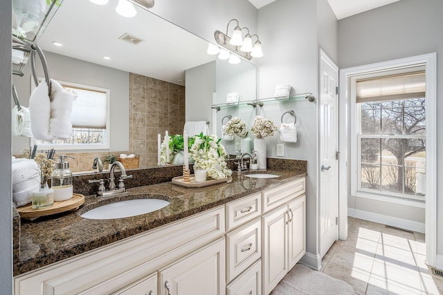 bathroom featuring tile patterned flooring, visible vents, and a sink