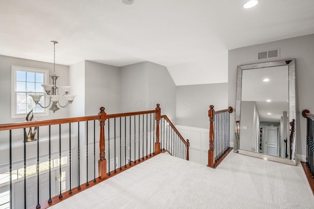 corridor with a wainscoted wall, visible vents, recessed lighting, an upstairs landing, and a chandelier