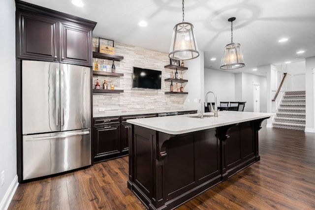 kitchen featuring a sink, light countertops, freestanding refrigerator, and open shelves