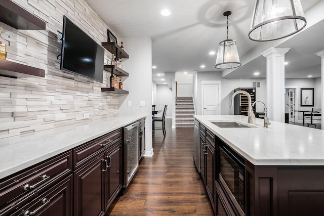 kitchen with beverage cooler, decorative backsplash, a center island with sink, open shelves, and built in microwave