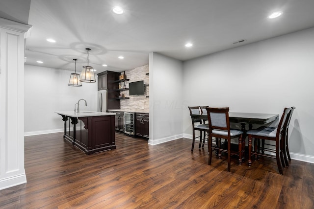 dining room featuring visible vents, beverage cooler, dark wood finished floors, recessed lighting, and wet bar