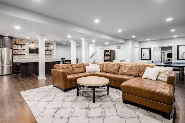 living room with recessed lighting, stairway, dark wood-style flooring, and ornate columns