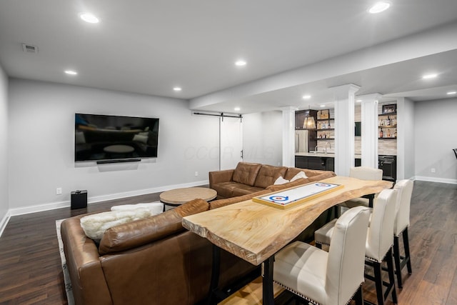 living area with recessed lighting, a barn door, and dark wood-type flooring