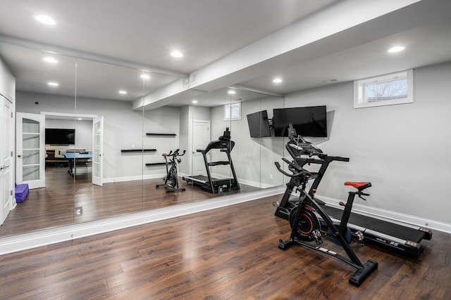 exercise room featuring recessed lighting, wood finished floors, and baseboards