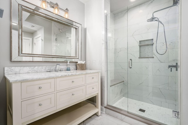 full bath with a marble finish shower, marble finish floor, and vanity