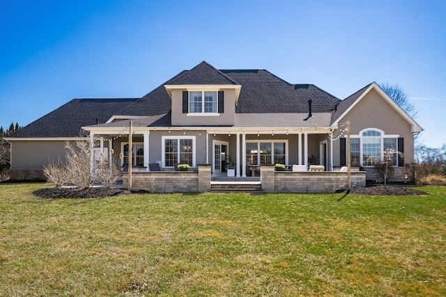 back of house with stucco siding, a patio, a yard, and a shingled roof