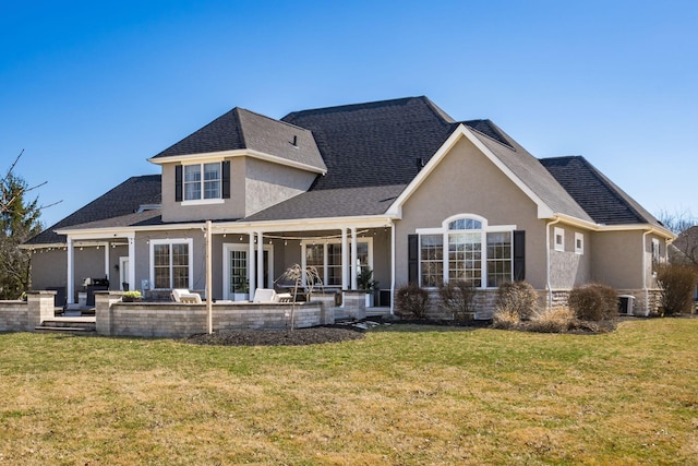 back of house with a yard, stucco siding, and a patio area