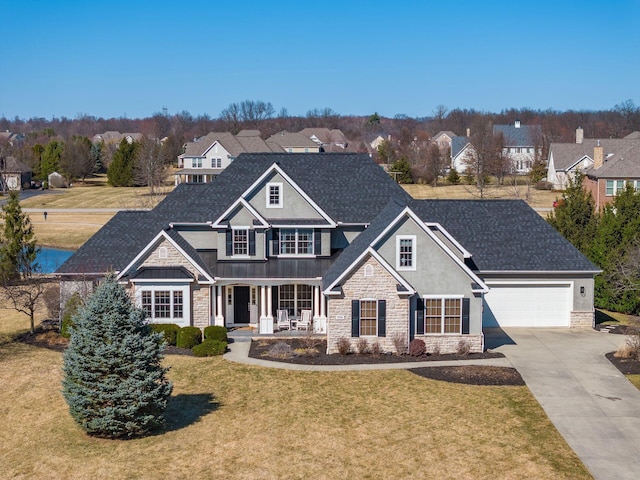 view of front of house featuring driveway, roof with shingles, a porch, a front lawn, and stone siding