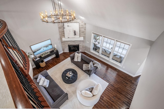 living area featuring baseboards, wood finished floors, a fireplace, and vaulted ceiling