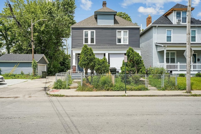 american foursquare style home with an outdoor structure, a gate, a fenced front yard, and roof with shingles