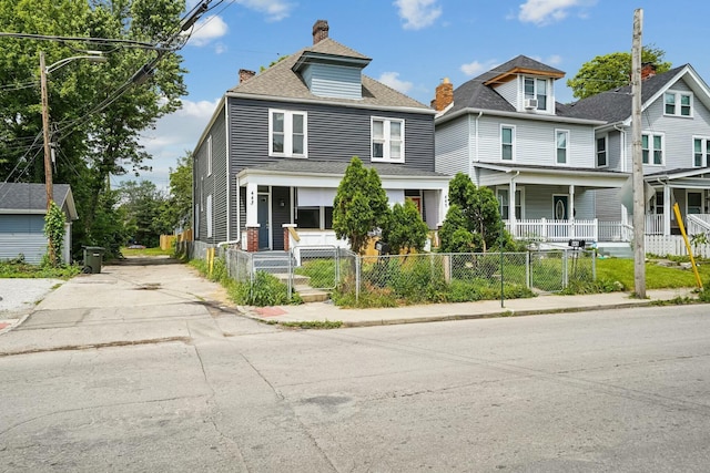 american foursquare style home with a shingled roof, a fenced front yard, covered porch, a chimney, and a gate