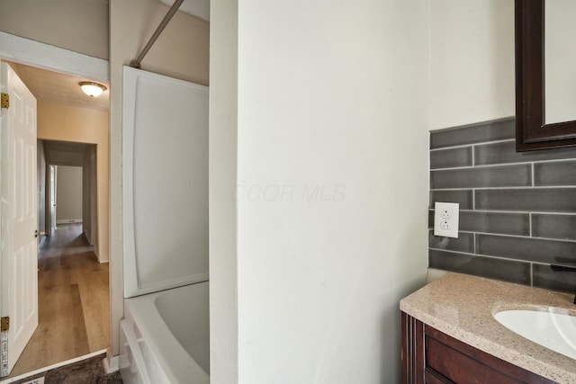 bathroom featuring vanity, a bath, and walk in shower