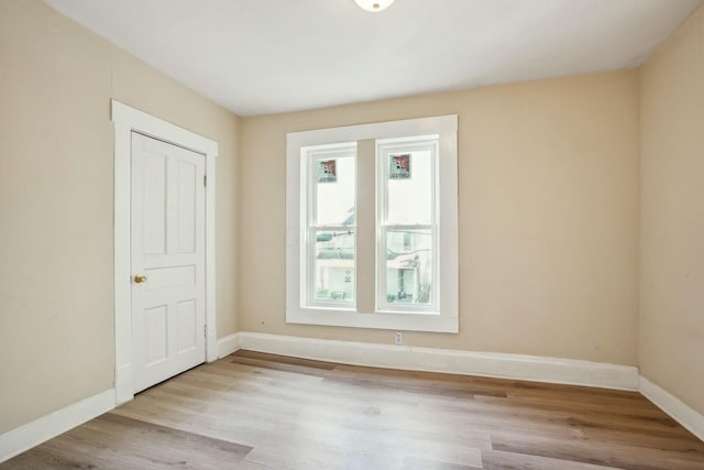 unfurnished room featuring baseboards and wood finished floors