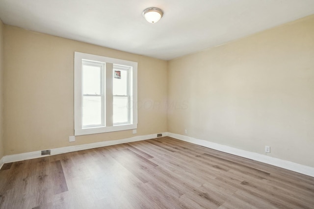 spare room with wood finished floors and baseboards