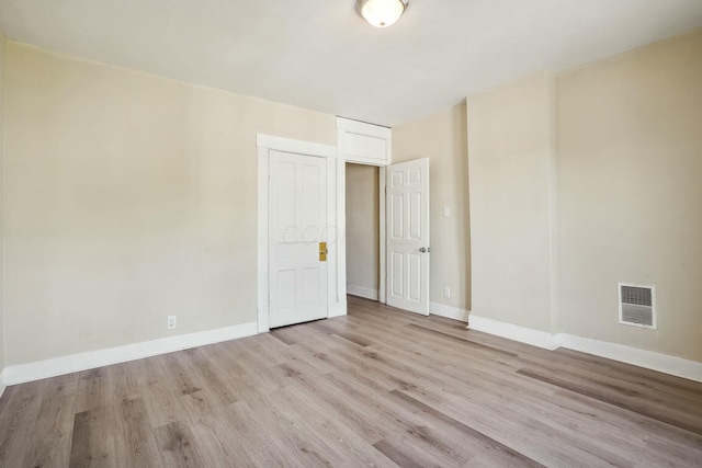 spare room with visible vents, light wood-style flooring, and baseboards