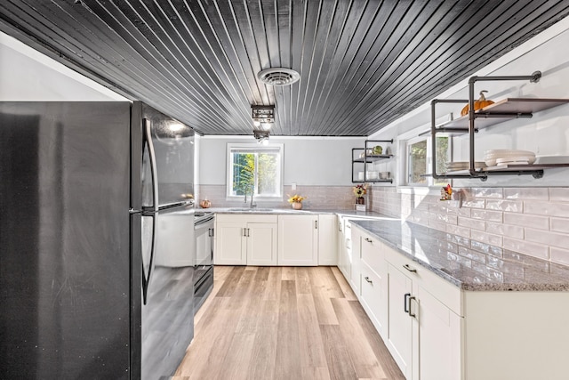 kitchen with visible vents, electric stove, open shelves, a sink, and freestanding refrigerator