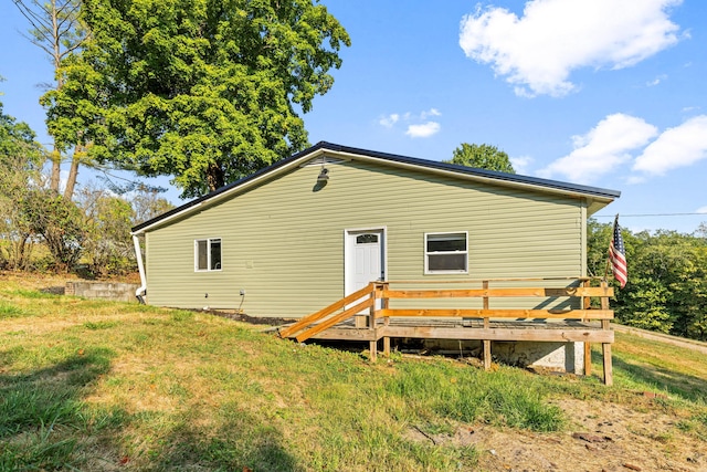 back of property featuring a lawn and a wooden deck