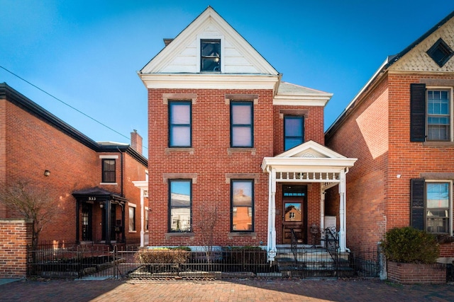 view of front of home featuring brick siding and a fenced front yard