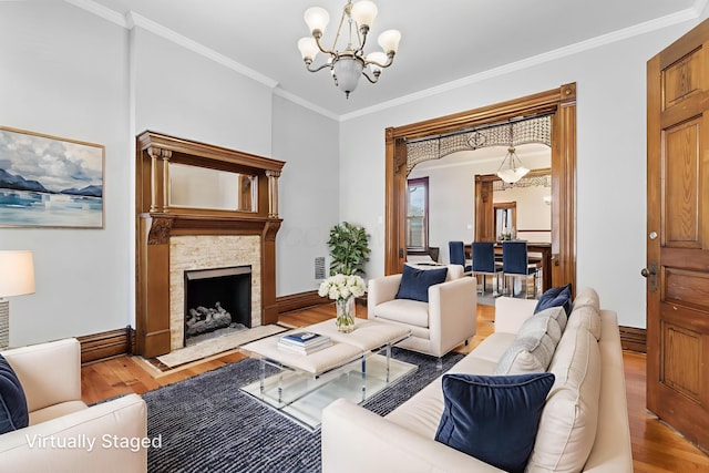 529 S 3rd St, Columbus, OH 43215 - living room with a chandelier, wood finished floors, crown molding, and a stone fireplace