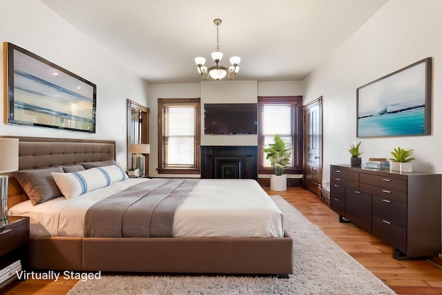 529 S 3rd St, Columbus, OH 43215 - bedroom with multiple windows, light wood-style flooring, a chandelier, and a fireplace