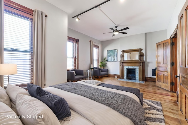 529 S 3rd St, Columbus, OH 43215 - bedroom with light wood-style floors, a fireplace, and ceiling fan