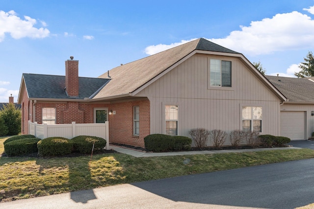 view of property exterior with brick siding, an attached garage, a chimney, and fence