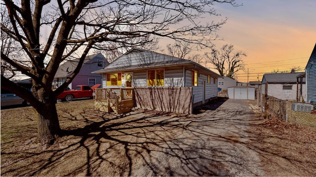 view of front facade featuring an outbuilding, a storage unit, and fence