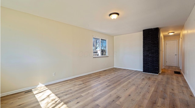 empty room with visible vents, baseboards, and light wood-style floors