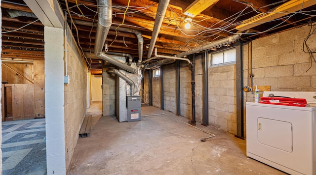 unfinished basement featuring heating unit and washer / clothes dryer