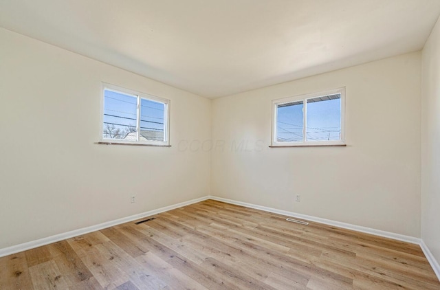 unfurnished room featuring visible vents, baseboards, a healthy amount of sunlight, and light wood finished floors