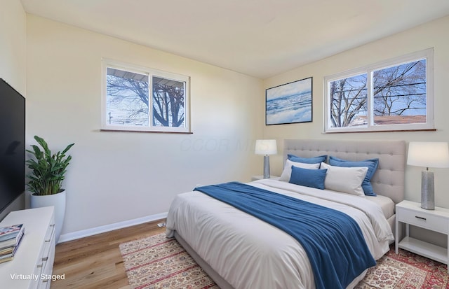 bedroom with baseboards and wood finished floors