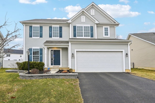 traditional home featuring aphalt driveway, an attached garage, and a front yard