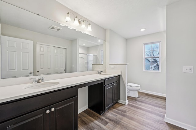 bathroom featuring a sink, visible vents, a stall shower, and double vanity