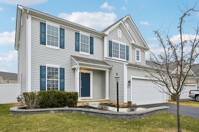 view of front of home with a garage, a front lawn, driveway, and fence